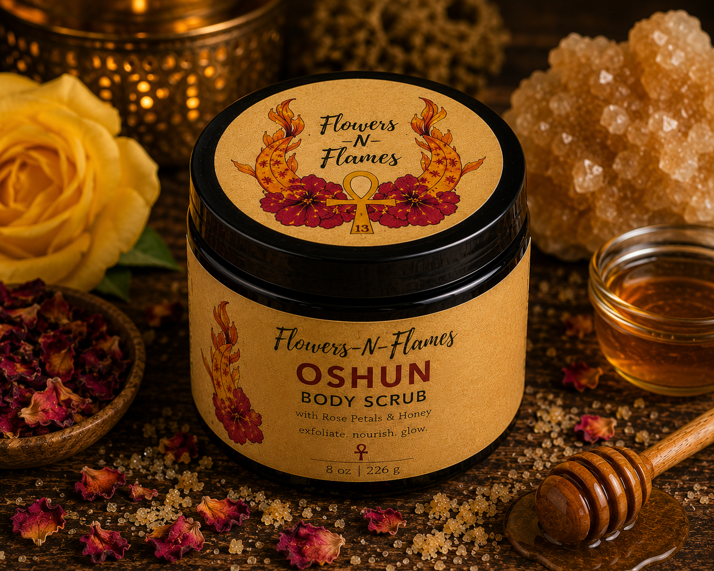 Flowers N Flames Oshun Body Scrub in a black jar with a kraft label, handcrafted with rose petals, honey, and botanical ingredients on a rustic wooden surface.